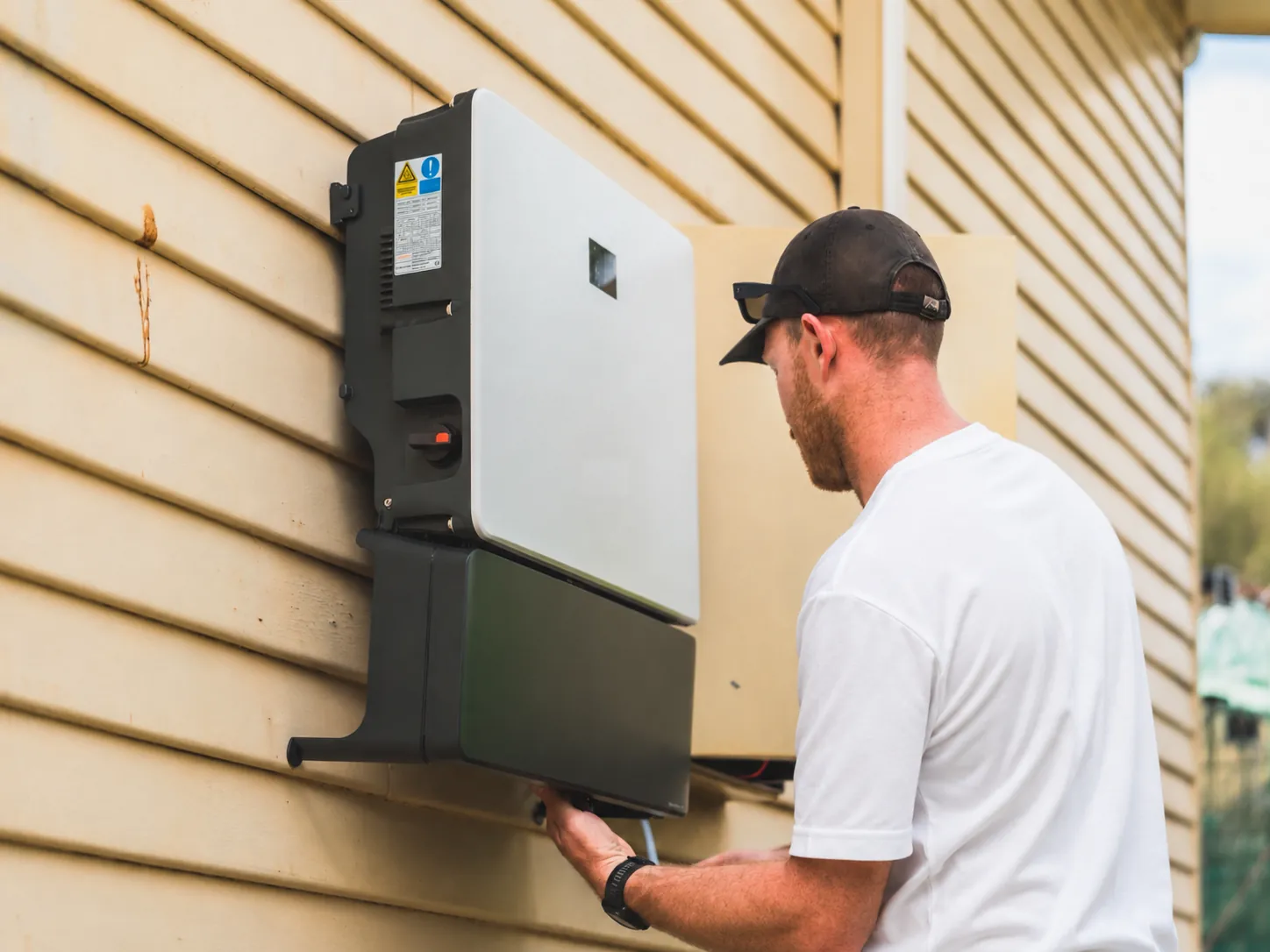 Hybride omvormer met batterijmodule aan de buitenmuur