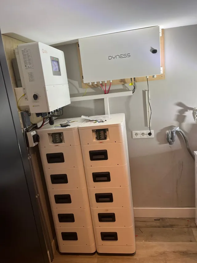 Twee Dyness-batterijtorens met een Solis-omvormer en Dyness-aansluitkast aan de wand van een binnenruimte.
